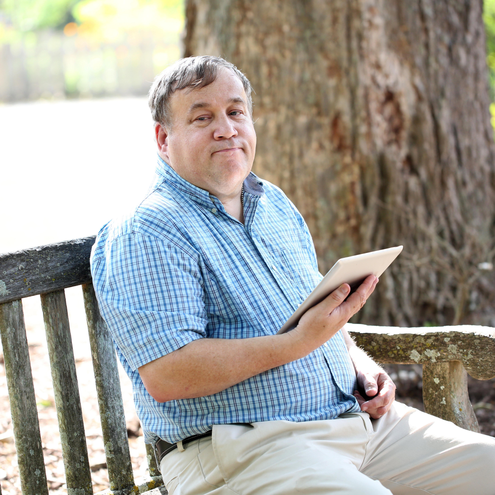 Man sitting on bench and using tablet