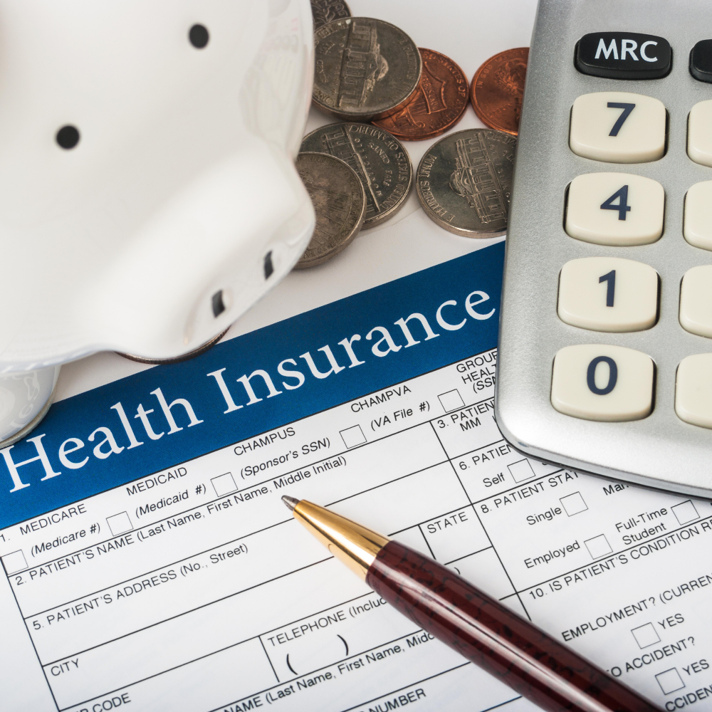 health insurance form, piggy bank, and calculator